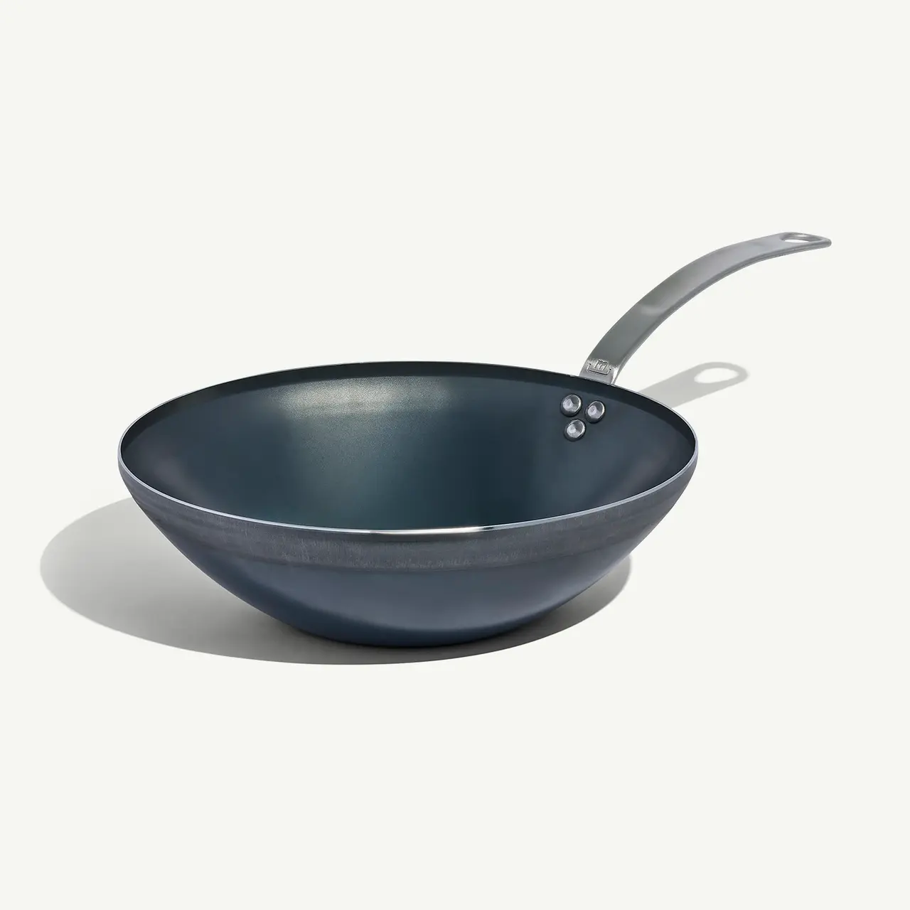 A non-stick frying pan with a silver handle is positioned against a plain background.