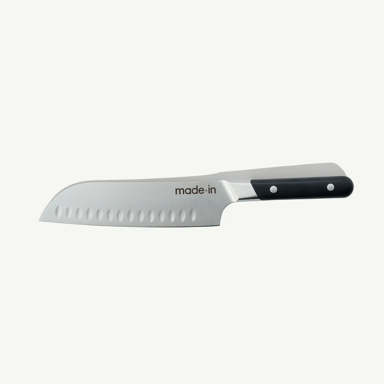 A stainless steel Santoku kitchen knife with a black handle is displayed against a white background.