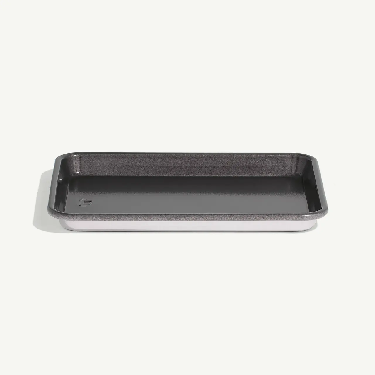 A rectangular black baking tray rests on a white surface.