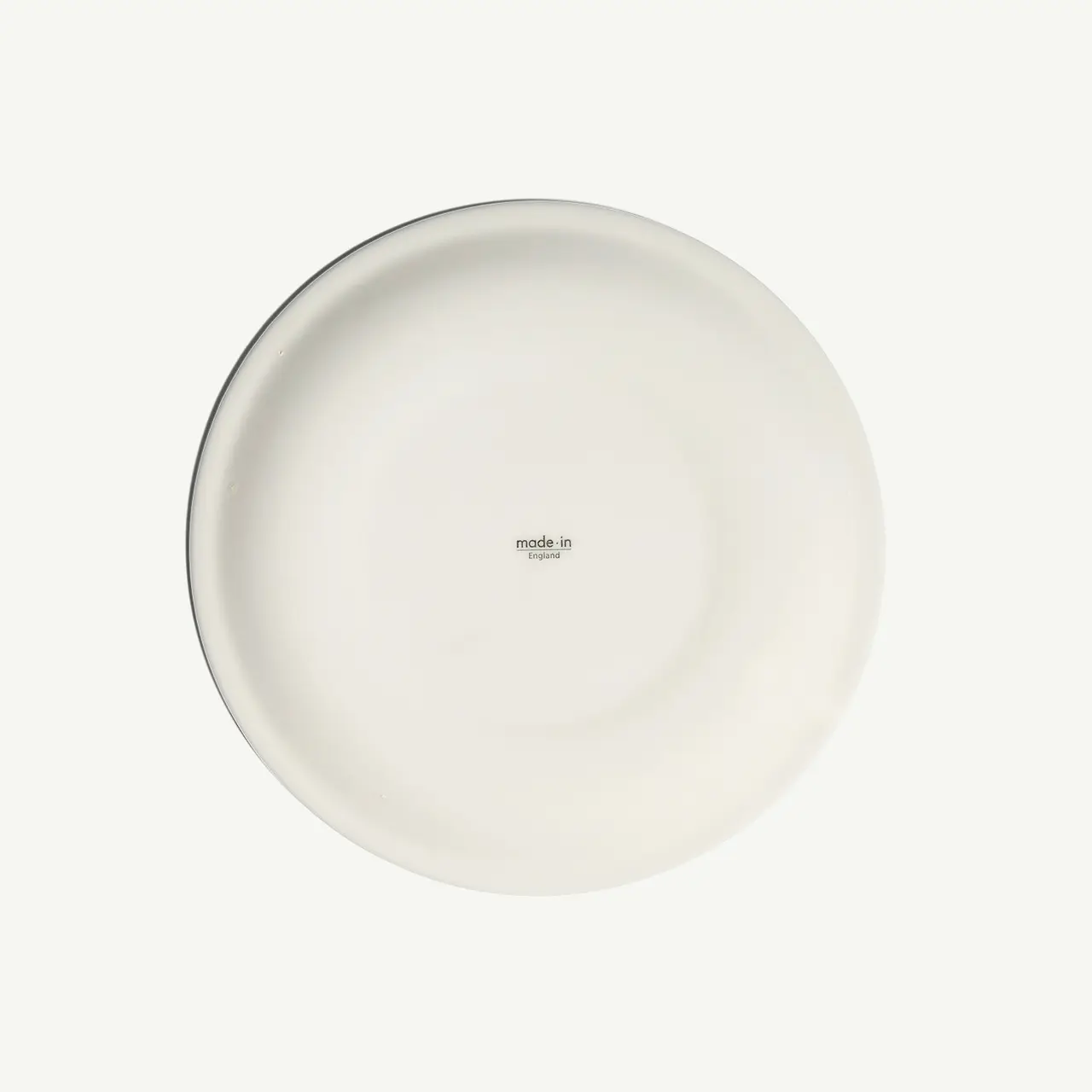 A plain white ceramic plate displayed against a matching background with the text "made in" visible at the center.