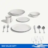 A collection of white dishware and silver utensils, including plates, bowls, a mug, forks, a knife, and serving spoons, displayed alongside wine glasses and labeled as a $99 value gift.