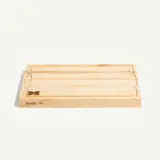 A rectangular wooden cutting board with a subtle engraved logo and the phrase "MADE IN" on one side.