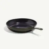A cast iron skillet with a dark interior and a green exterior, featuring a handle for easy lifting.