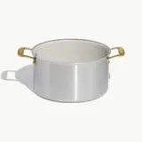A shiny silver cooking pot with gold handles and a smooth interior.