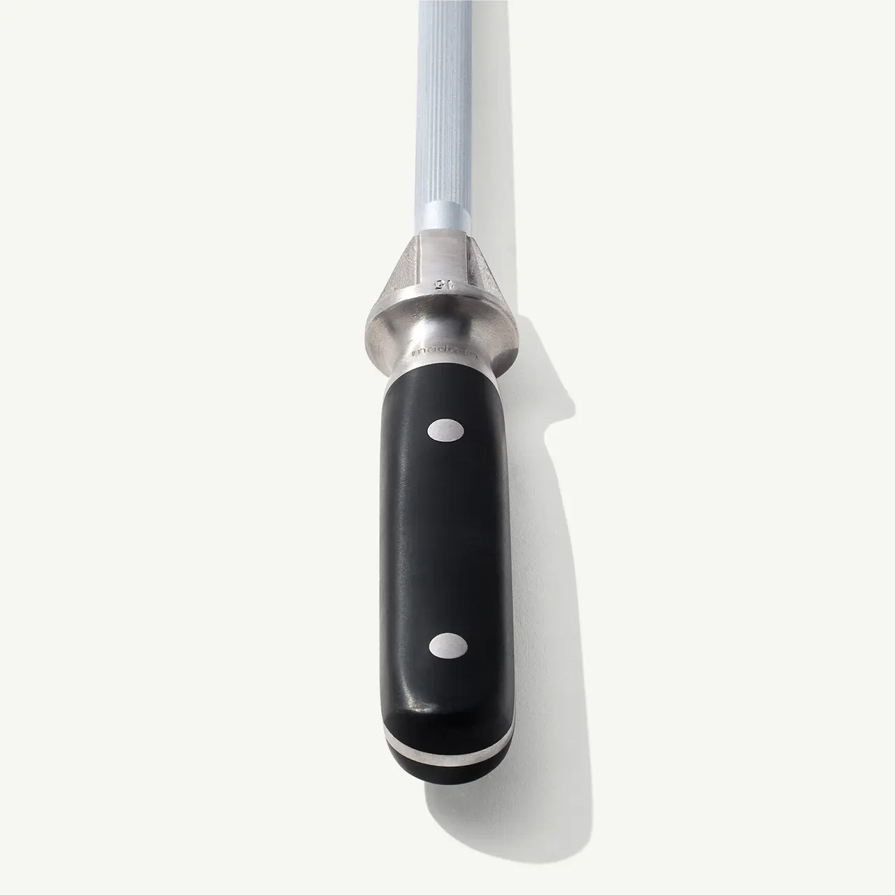 A chef's knife with a black handle is displayed on a white background, casting a soft shadow.
