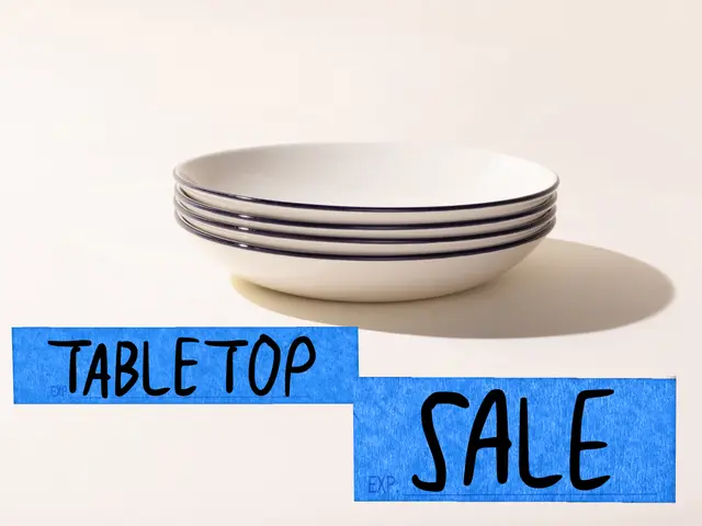 A stack of white bowls with blue stripes on a tabletop with a paper banner reading "TABLETOP SALE" underneath.