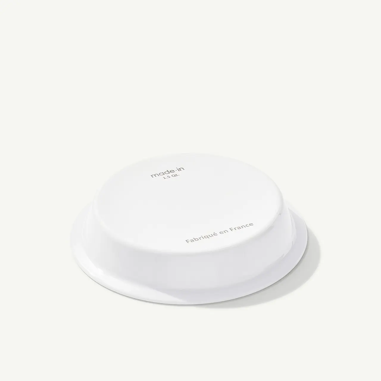A minimalist white wireless charger with centered text on a plain background.