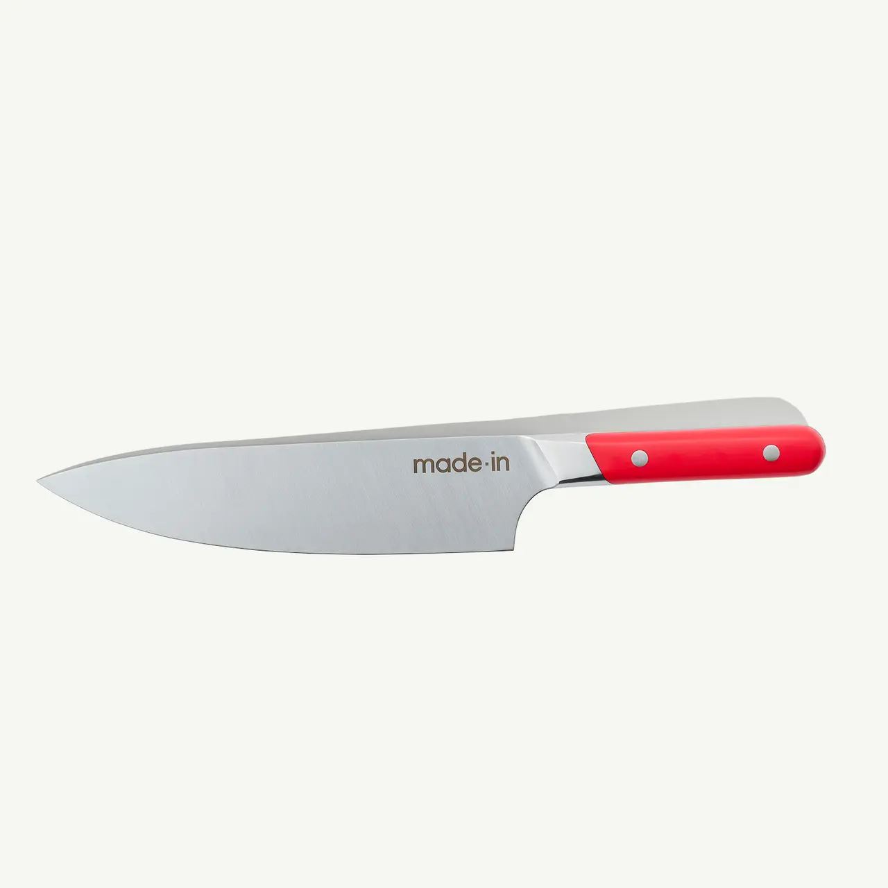 A stainless steel chef's knife with a red handle isolated on a white background.