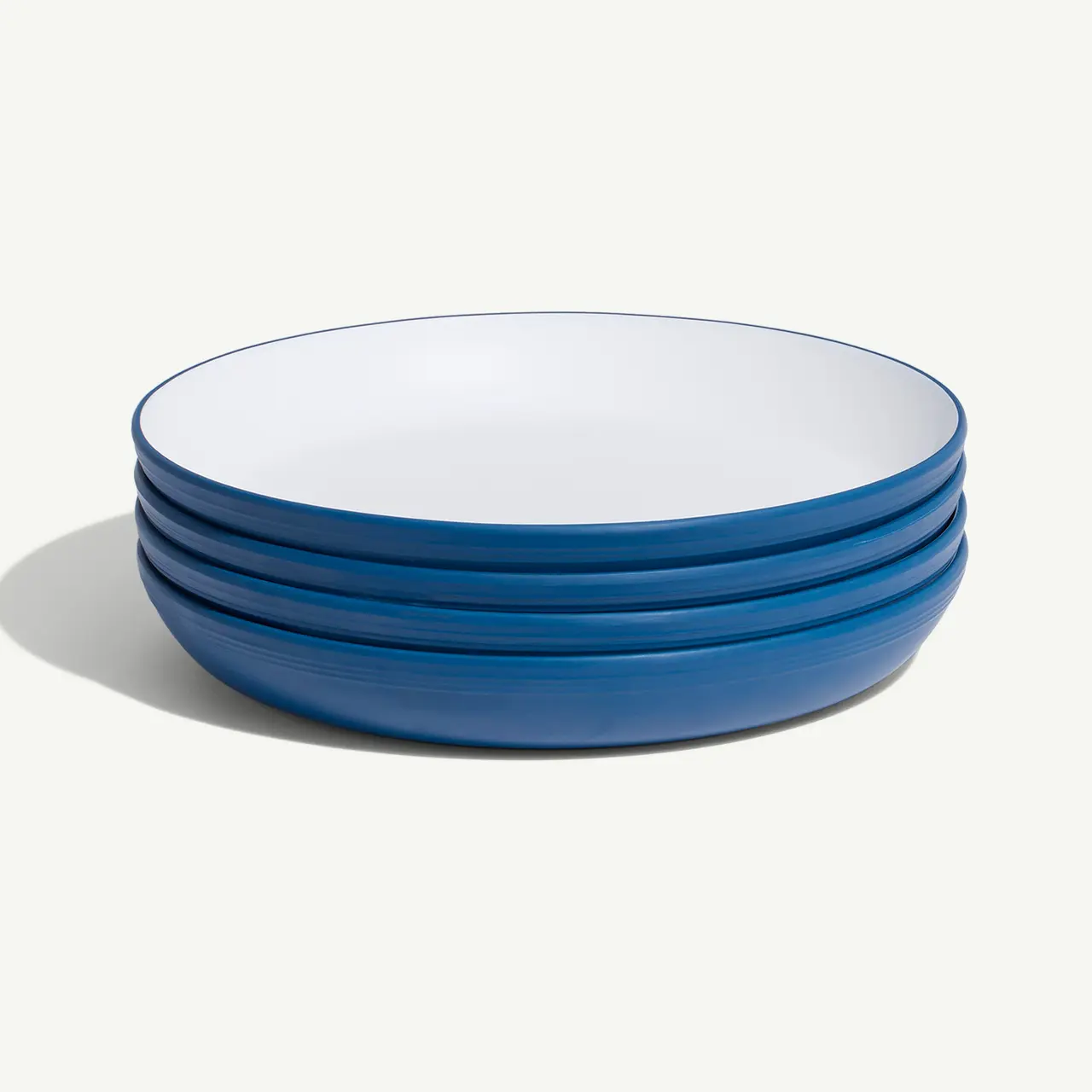 A stack of blue-rimmed white plates on a light background.