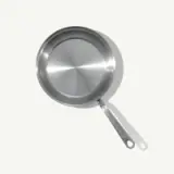A stainless steel frying pan is shown against a light gray background, viewed from above.