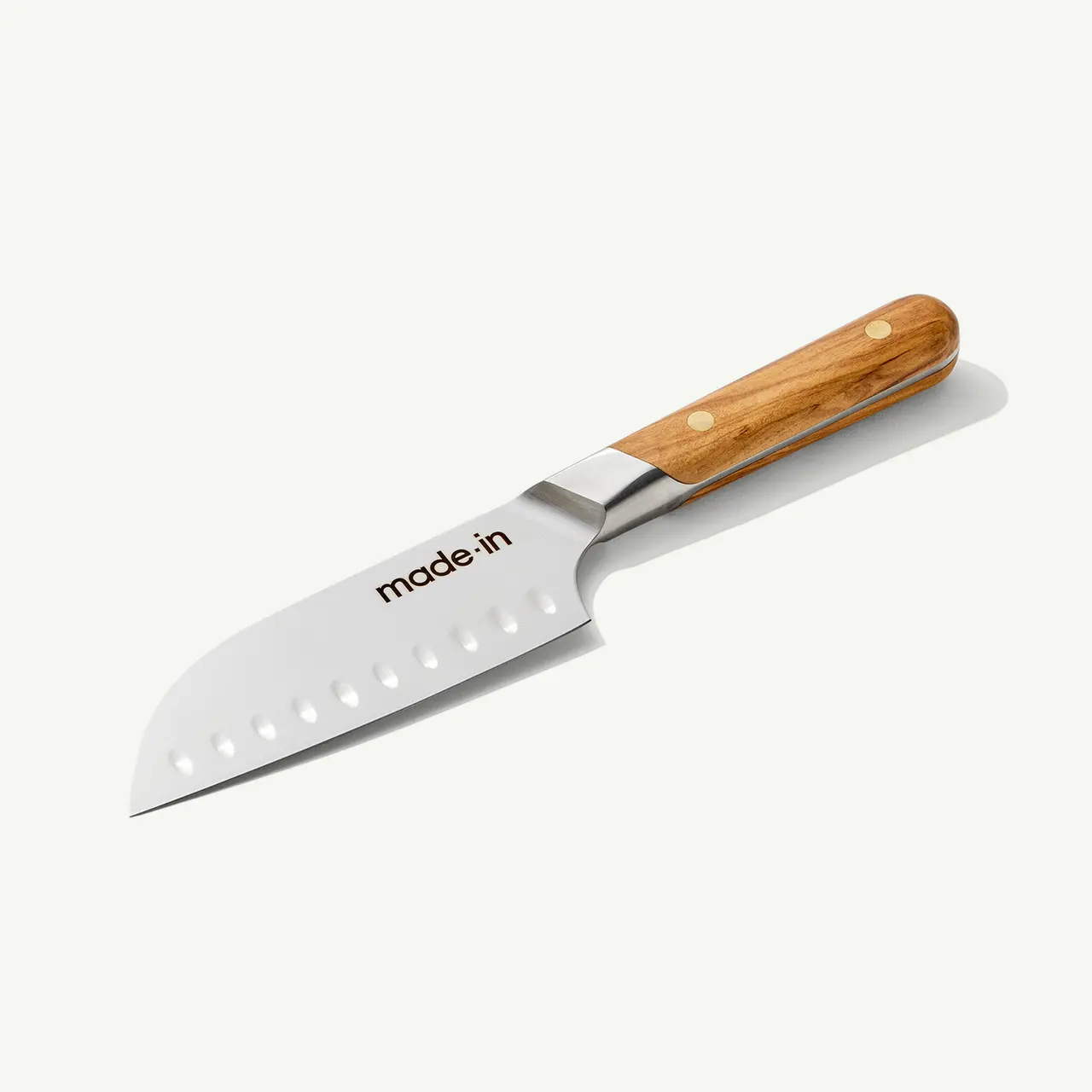 A stainless steel chef's knife with a wooden handle and branded text lies against a plain background.
