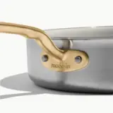 A sleek stainless steel pan with a gold-tone handle, featuring a label that says "made-in."