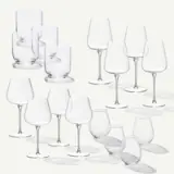 A collection of various clear glassware, including different styles of wine glasses and tumblers, arranged aesthetically against a light background.