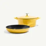 A bright yellow frying pan and a matching covered saucepan are displayed together.