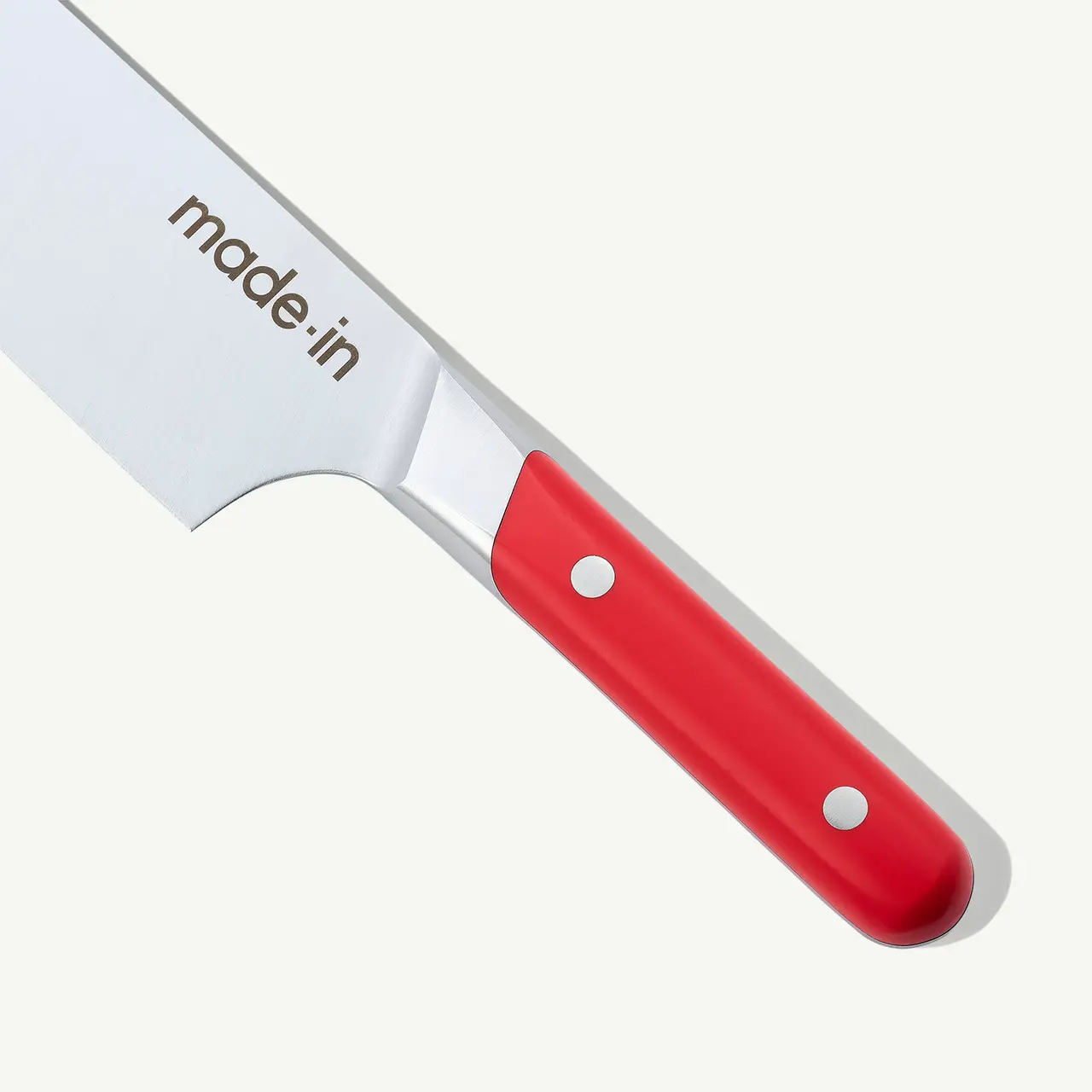 A close-up view shows a kitchen knife with a red handle and the text "made.in" printed on its blade.