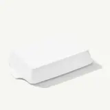 A sleek white wireless router with minimalistic design sits on a plain surface.