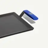 A flat, rectangular griddle with a blue handle and a smooth cooking surface.