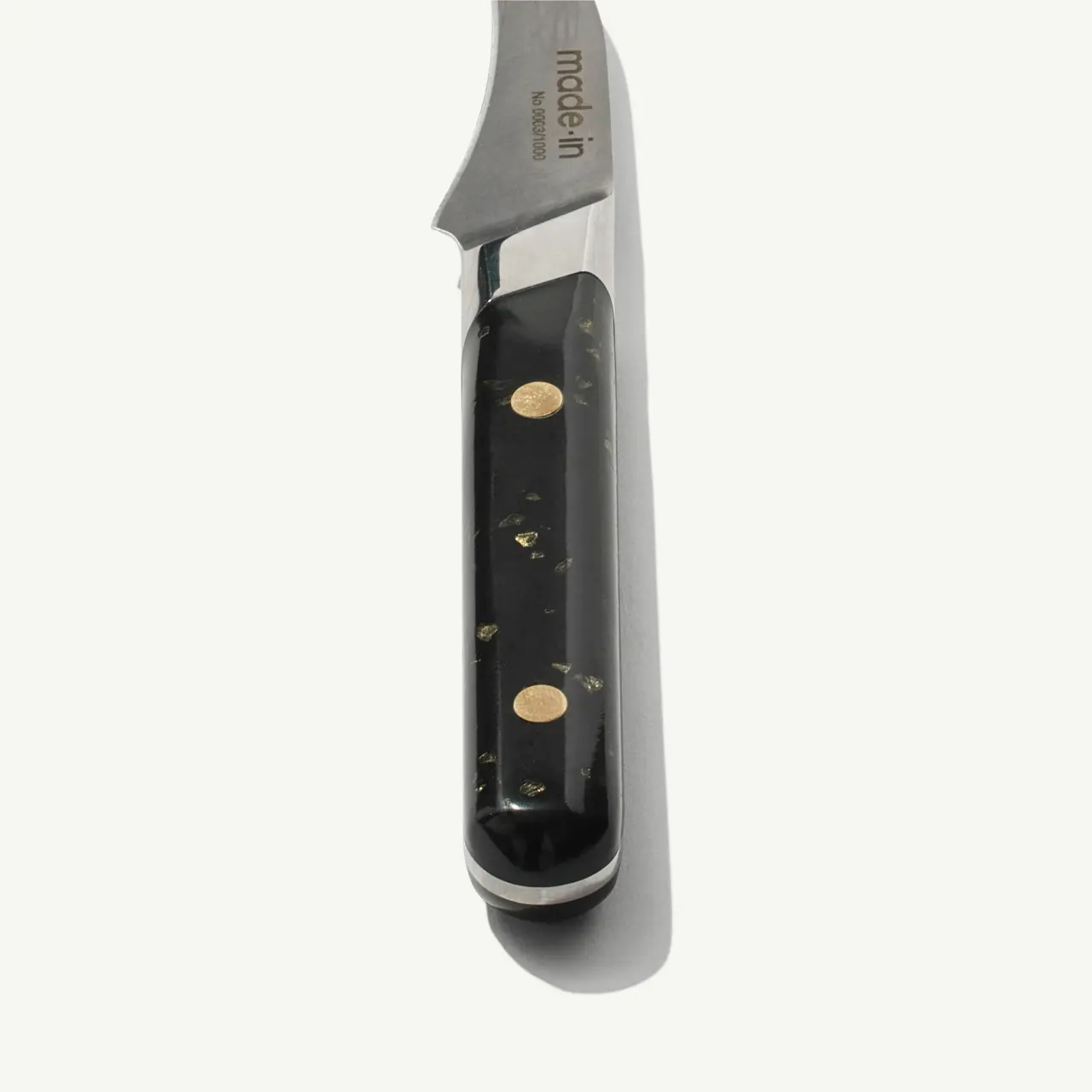 A close-up view of a pocket knife with a black handle and metallic blade against a white background.