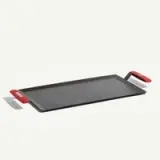 A flat cooking tray with red handles designed for grilling or baking.