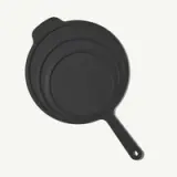 A black, non-stick skillet with a handle, featuring a simple and modern design.