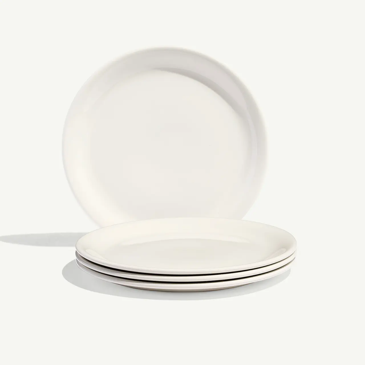 Three stacked white plates are presented against a plain background.