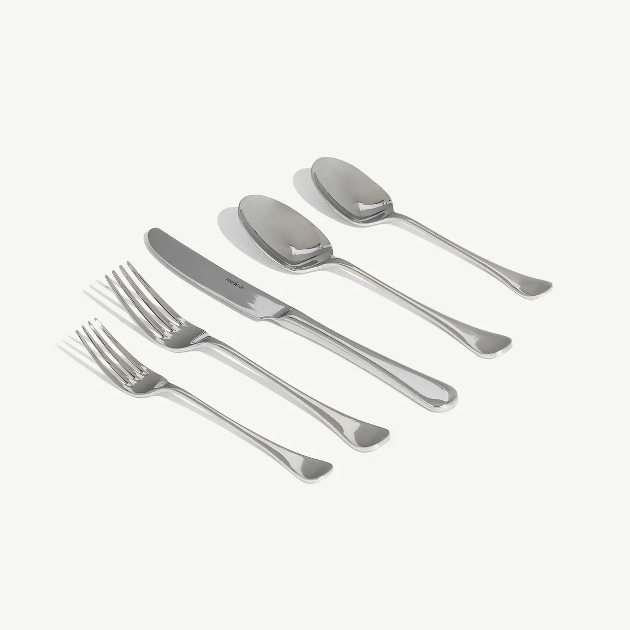 A set of silverware, including forks, a knife, and spoons, is neatly arranged on a light background.