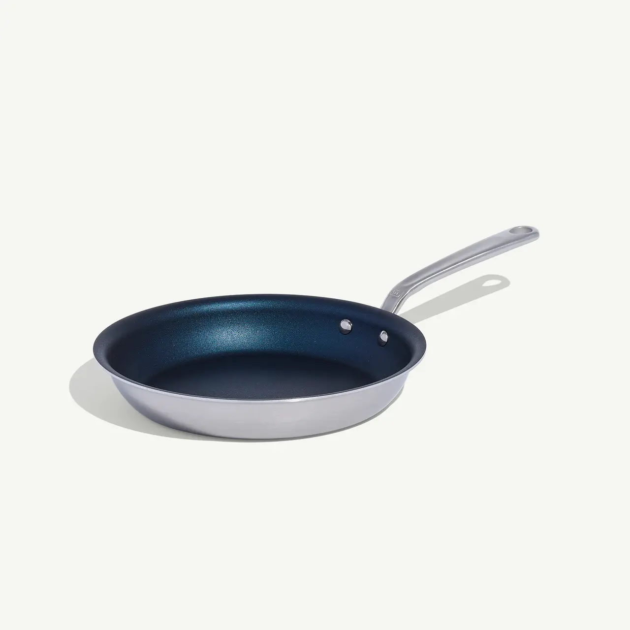 A non-stick frying pan with a silver handle is isolated against a white background.