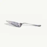 A stainless steel cake server with a triangular blade lies on a light background.