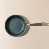 Non-stick frying pan with a silver handle set against a simple, neutral background.