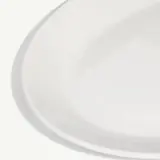 A clean, white ceramic plate angled slightly on a white background.
