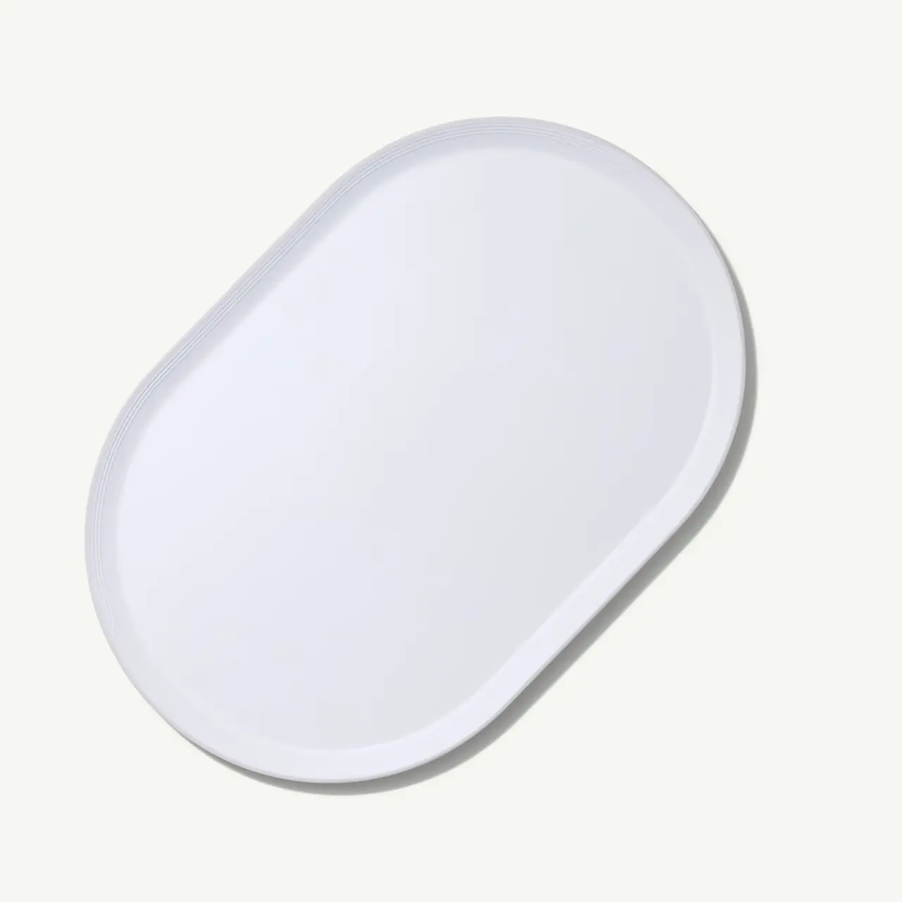 A plain white oval-shaped plate is centered against a light background.