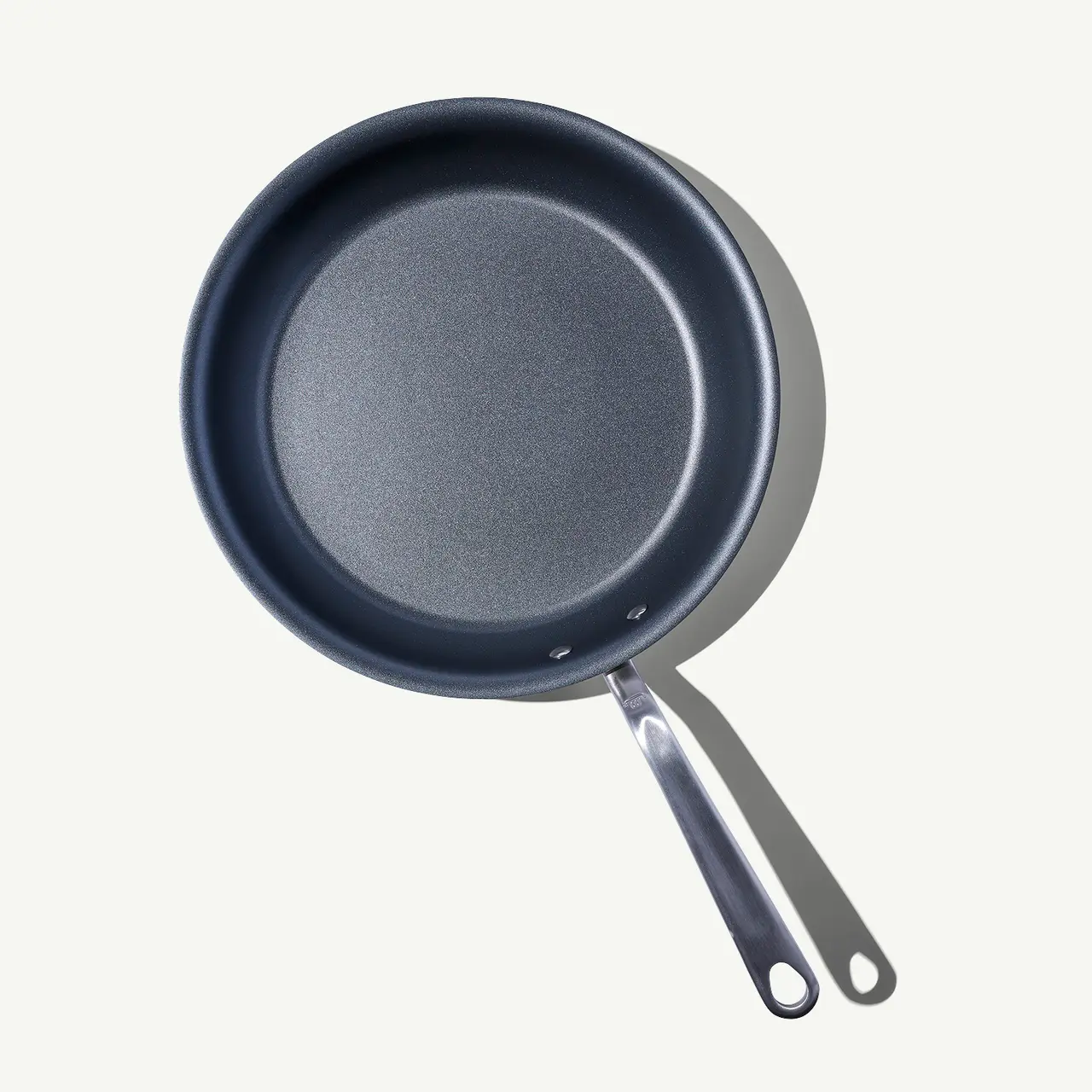 A top-down view of two non-stick frying pans with silver handles on a light background.