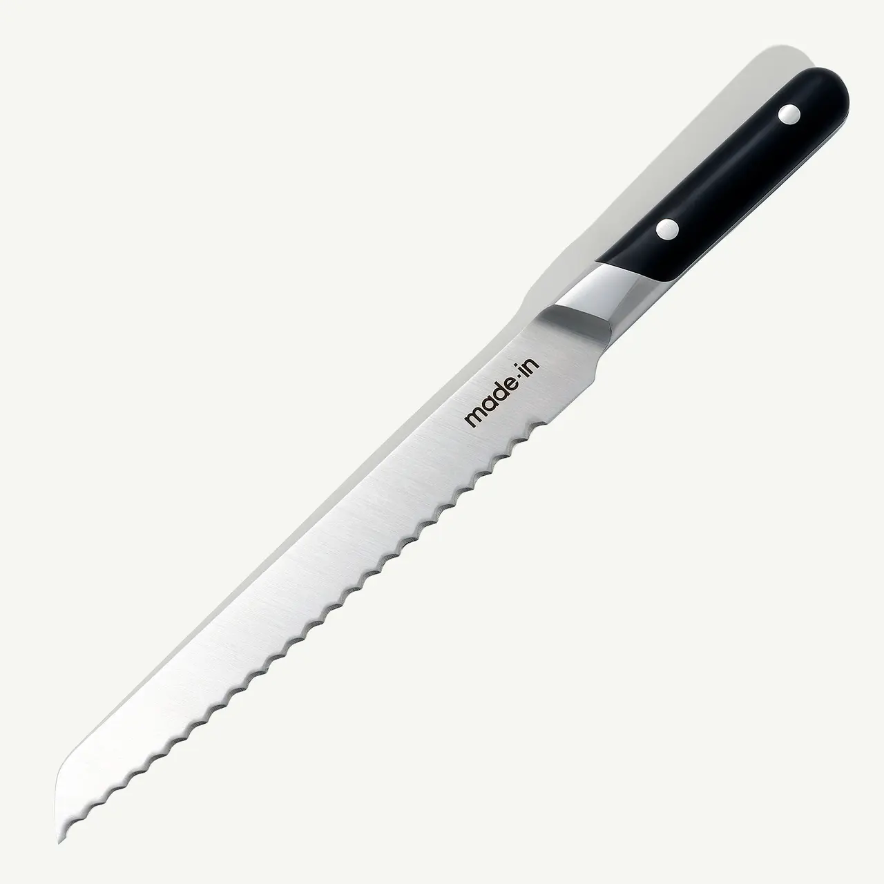 A serrated bread knife with a black handle on a white background.