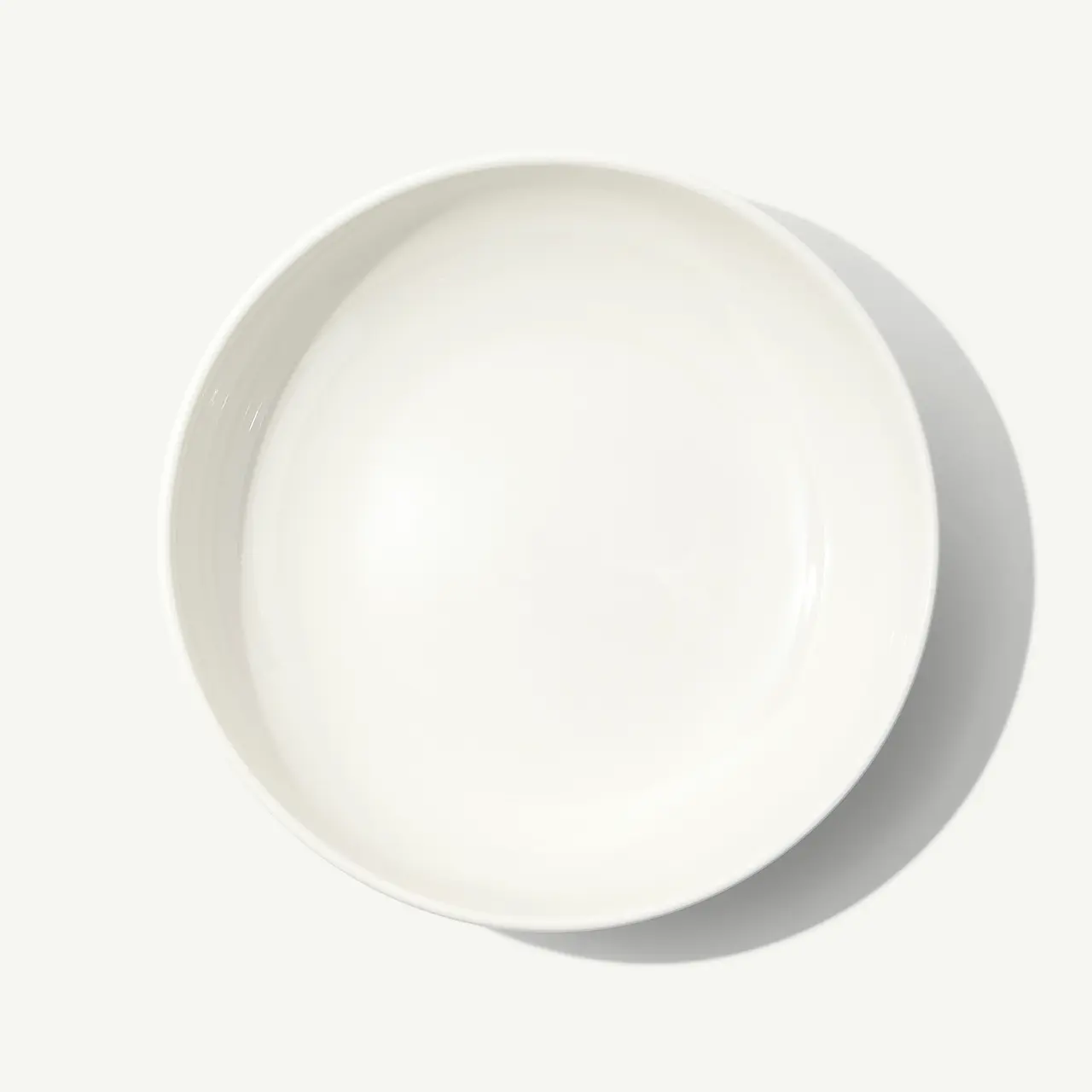 A plain white circular plate is centered on a light background.