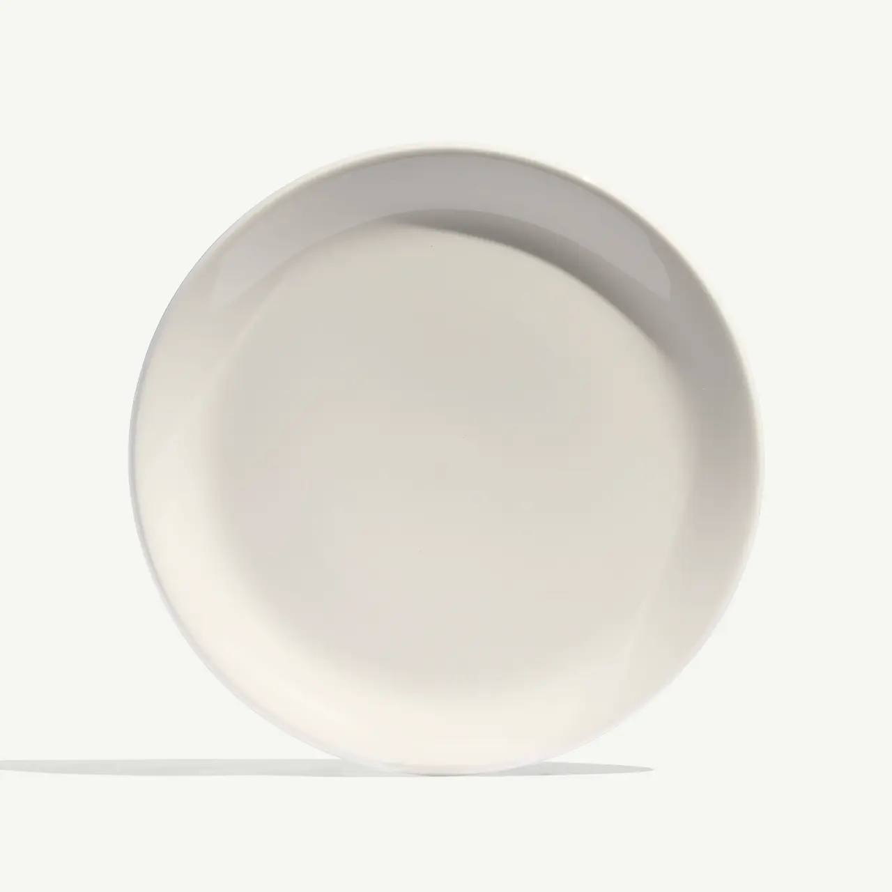A plain white plate is presented against a soft white background, casting a subtle shadow.