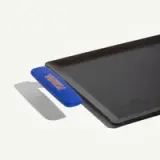 A rectangular black griddle with a blue handle labeled "Frywall."