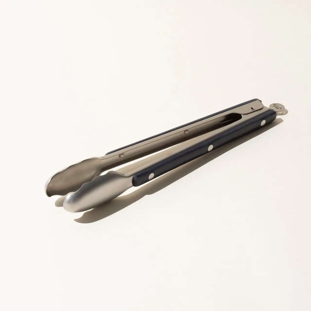 A closed multi-tool pocket knife with pliers on one end, lying on a plain light background.