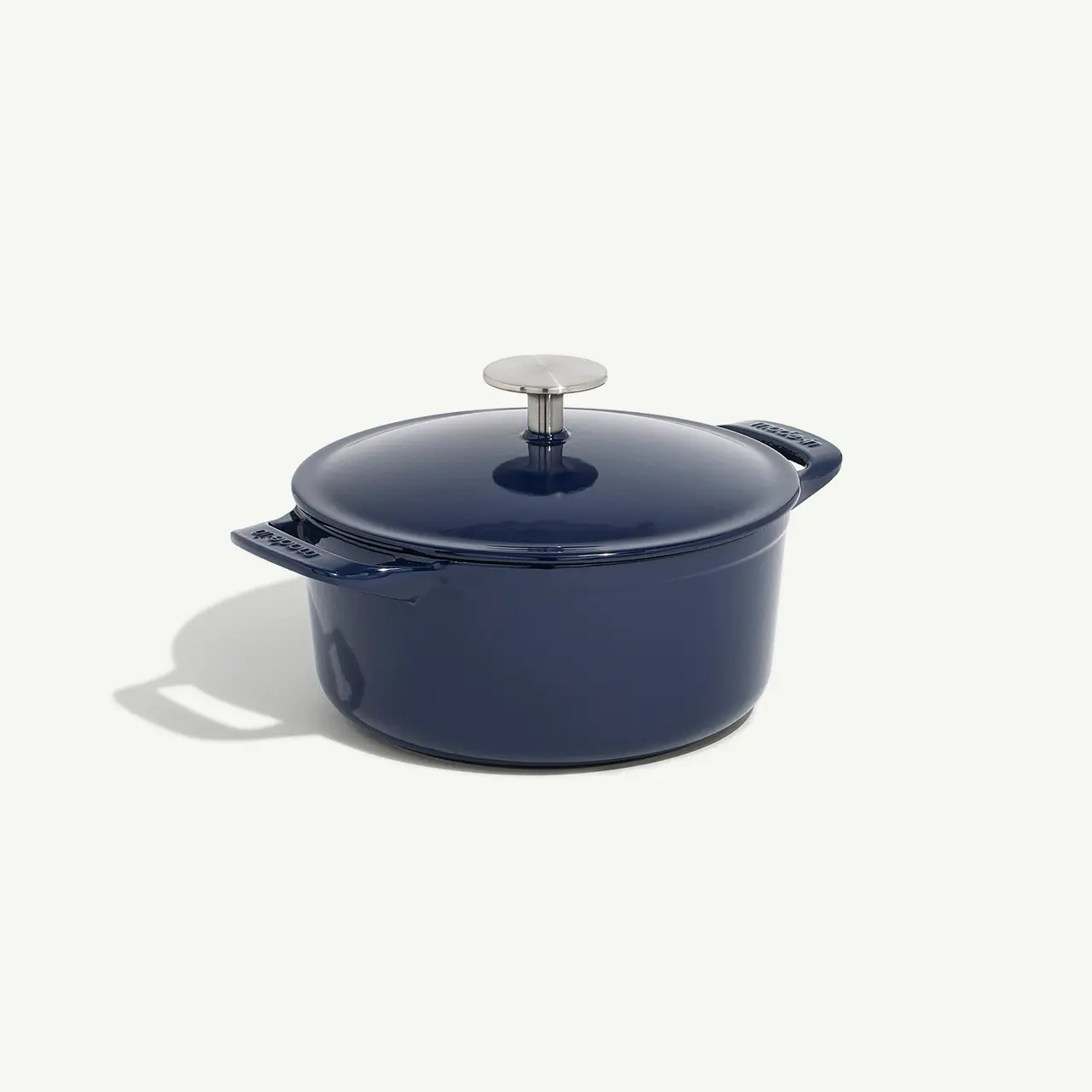 A blue enameled cast iron Dutch oven with a lid on a white background.