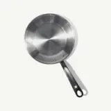 A stainless steel frying pan with a black handle is depicted against a light background.