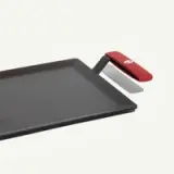 A rectangular cooking griddle with a red handle and a sleek, flat surface.