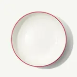 A white, empty bowl with a red rim is centered on a plain background.
