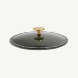 A sleek, round pot lid with a golden knob on top, featuring a dark green finish.