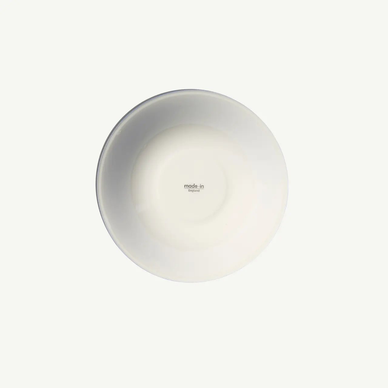 A plain white plate with "made in" text at the center against a light background.