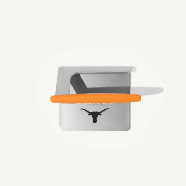 A silver metal object with an orange handle and a logo featuring a longhorn silhouette.