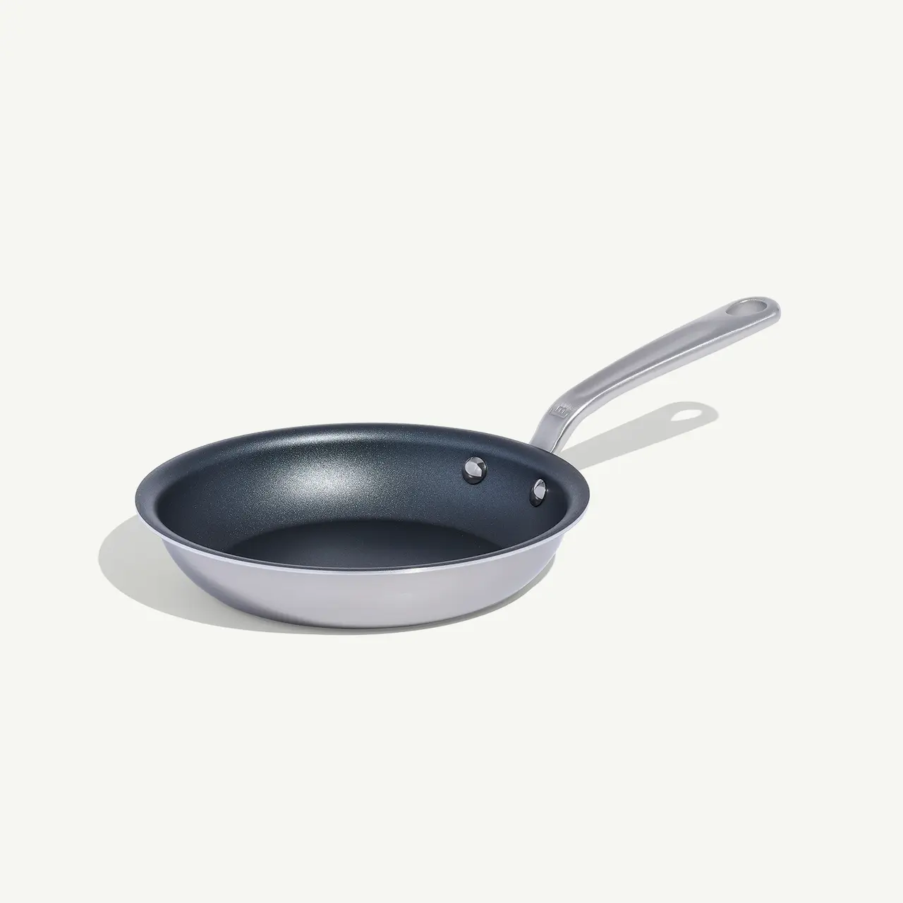 A non-stick frying pan with a silver handle is presented against a white background.