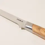 A close-up view of a kitchen knife with a wooden handle and the words "made-in" printed on the blade.
