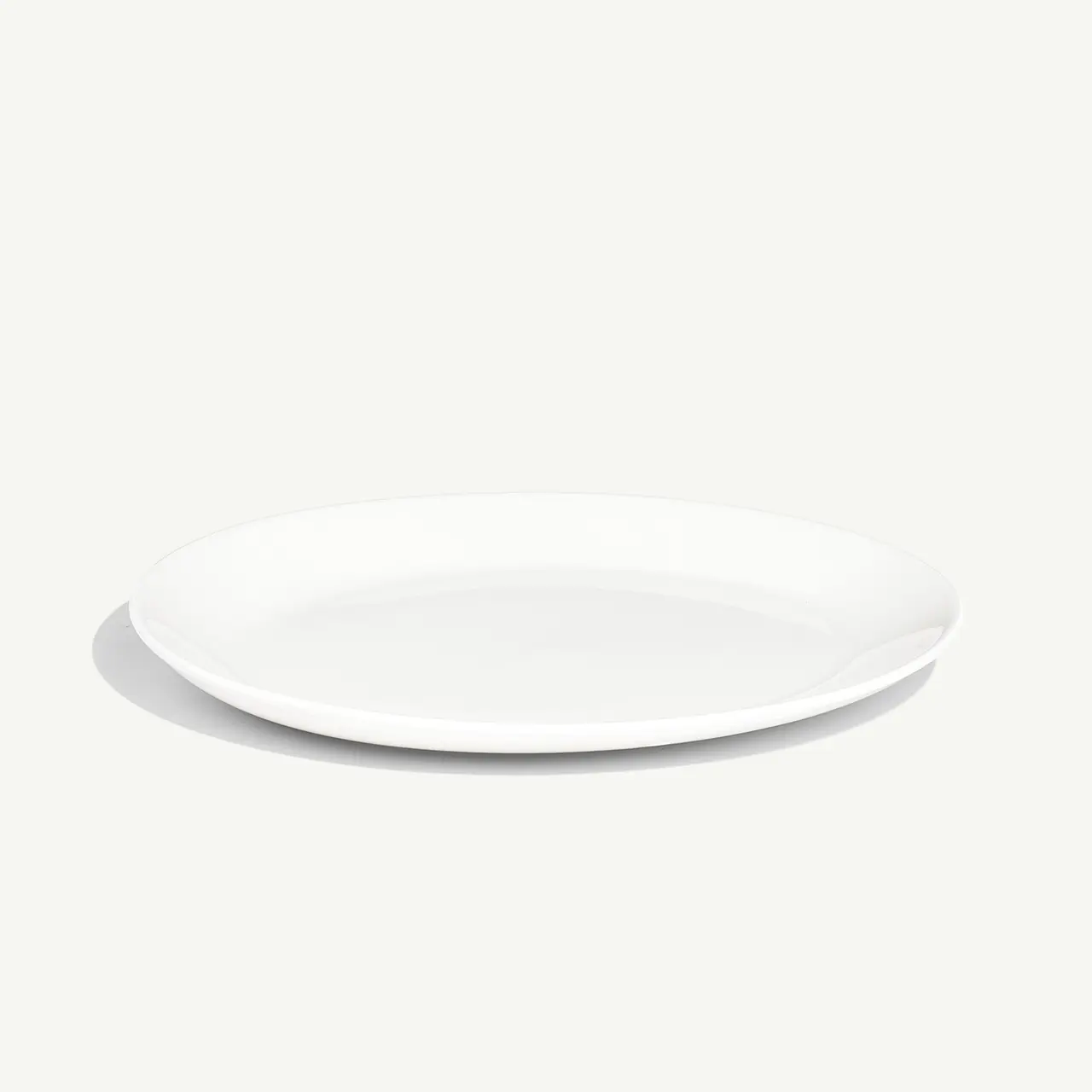 A simple white plate is placed against a light grey background.