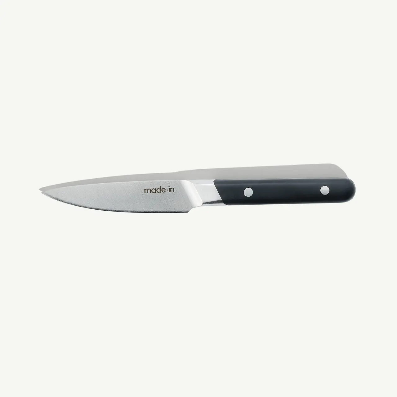 A stainless steel chef's knife with a black handle is displayed against a white background.