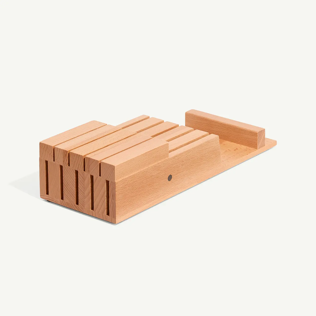 A wooden knife block with slots for storing kitchen knives sits against a light background.