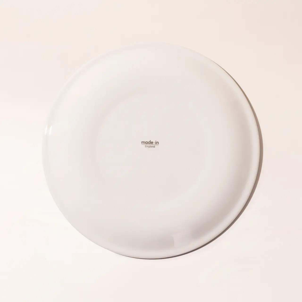 A plain white plate with a small text "made.in" in the center sits against a light background.